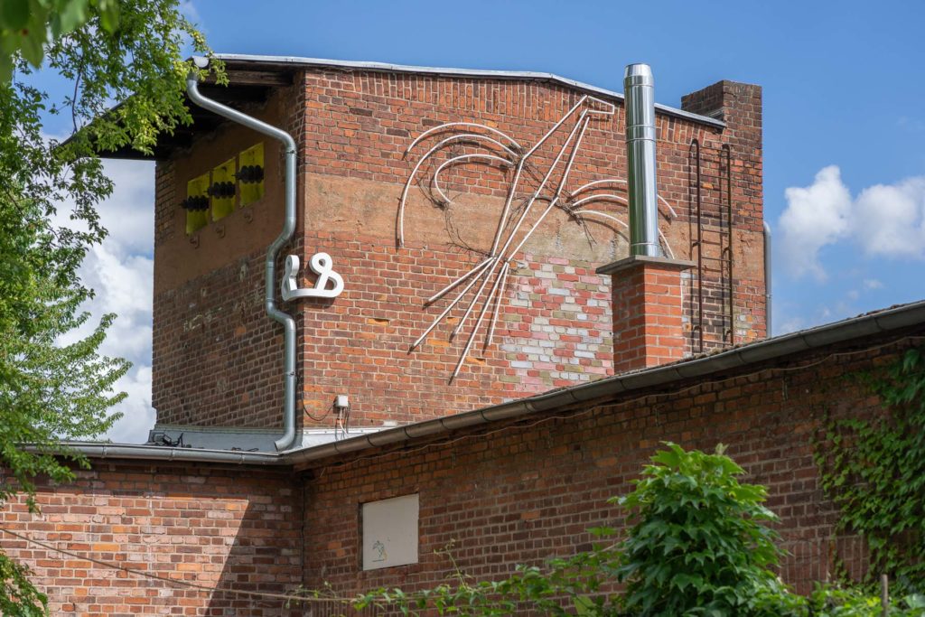 Ampersand und stilisierter Vogel am Haus am Wehrsteg in Heidelberg.